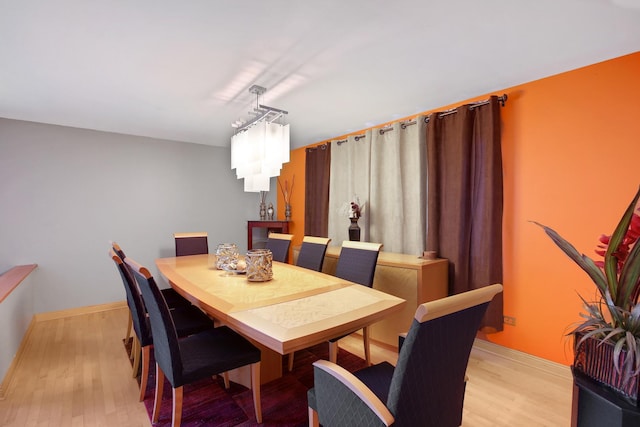 dining room featuring light wood-type flooring and baseboards