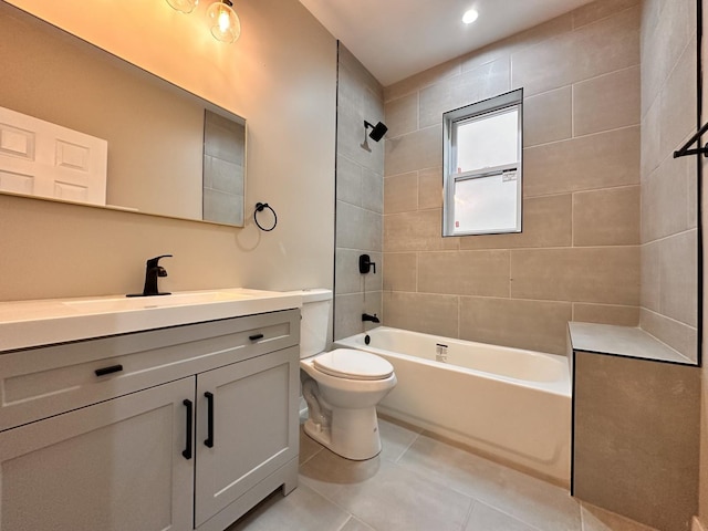 full bathroom with tile patterned floors, tiled shower / bath combo, vanity, and toilet