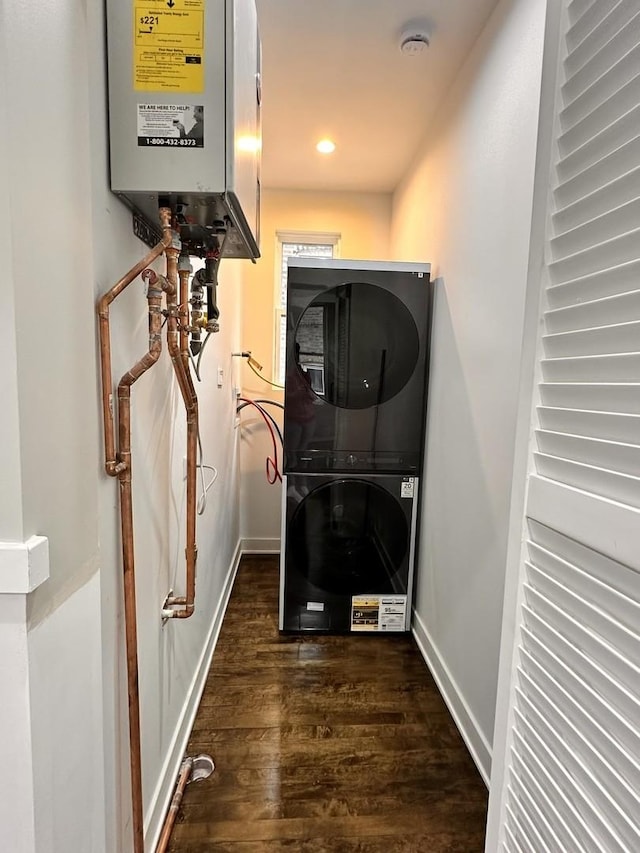 interior space featuring water heater, dark wood-type flooring, and stacked washer / drying machine