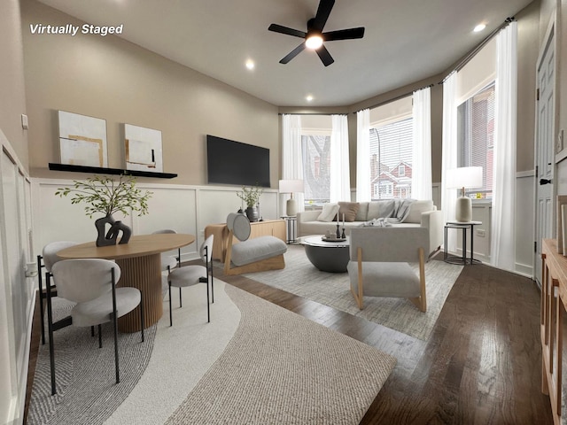 living room featuring ceiling fan and dark hardwood / wood-style floors