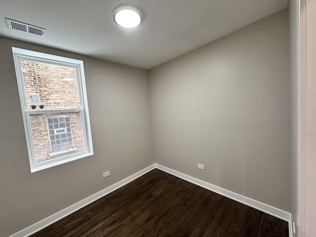 spare room featuring dark wood-type flooring and a wealth of natural light