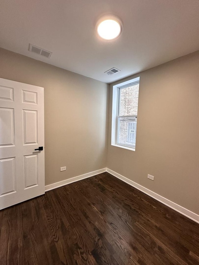 unfurnished room with dark hardwood / wood-style flooring