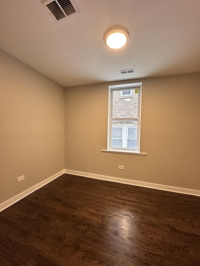 unfurnished room with dark hardwood / wood-style flooring