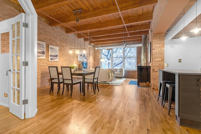 dining room featuring wood ceiling, brick wall, light hardwood / wood-style flooring, and beamed ceiling