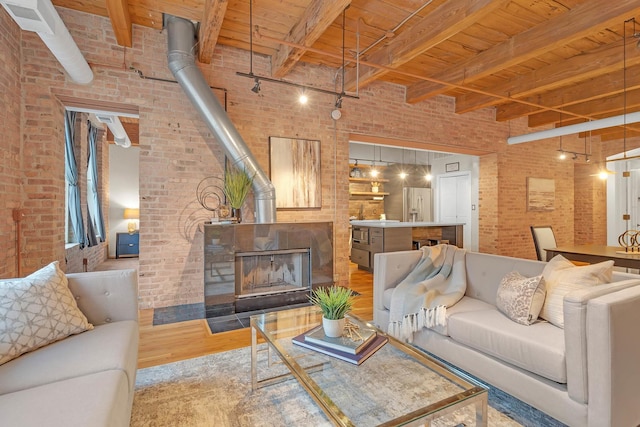 living room with wood ceiling, wood-type flooring, brick wall, and a wood stove