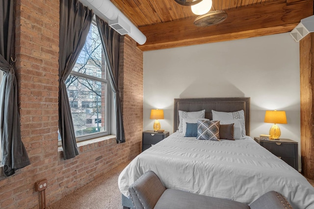 bedroom featuring carpet, wooden ceiling, and brick wall