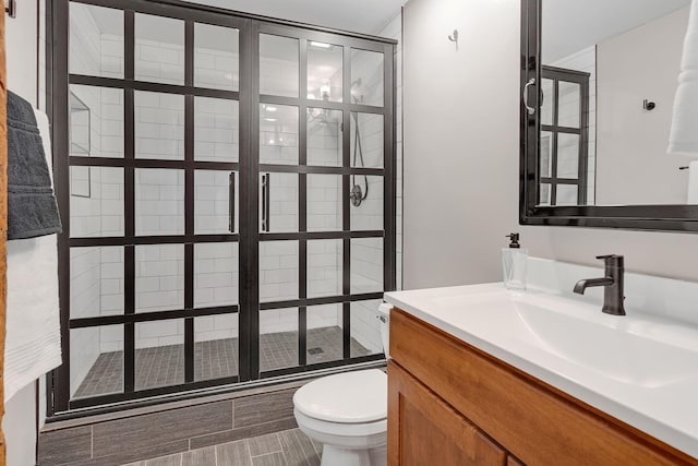 bathroom featuring vanity, toilet, and tiled shower