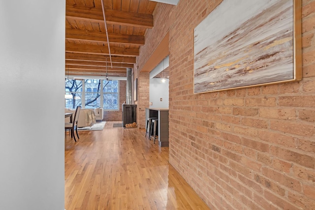 hall with wood ceiling, brick wall, beam ceiling, and light wood-type flooring