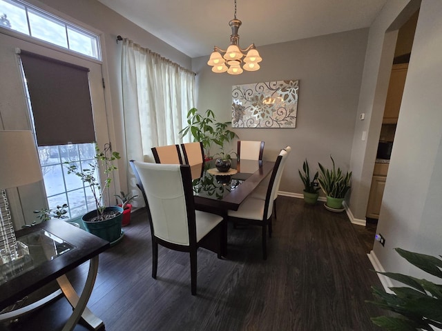 dining area featuring dark wood-type flooring and a chandelier