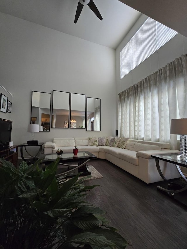 living room with a high ceiling, ceiling fan, and hardwood / wood-style flooring