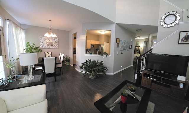 living room with dark wood-type flooring and a notable chandelier