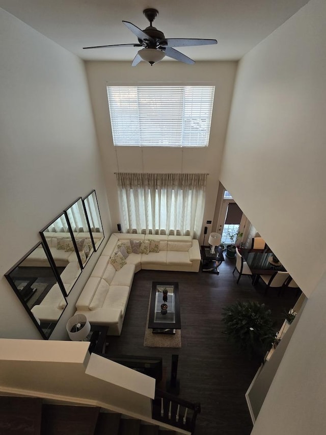 living room featuring ceiling fan and a towering ceiling