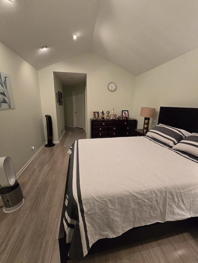 bedroom with vaulted ceiling and dark hardwood / wood-style floors