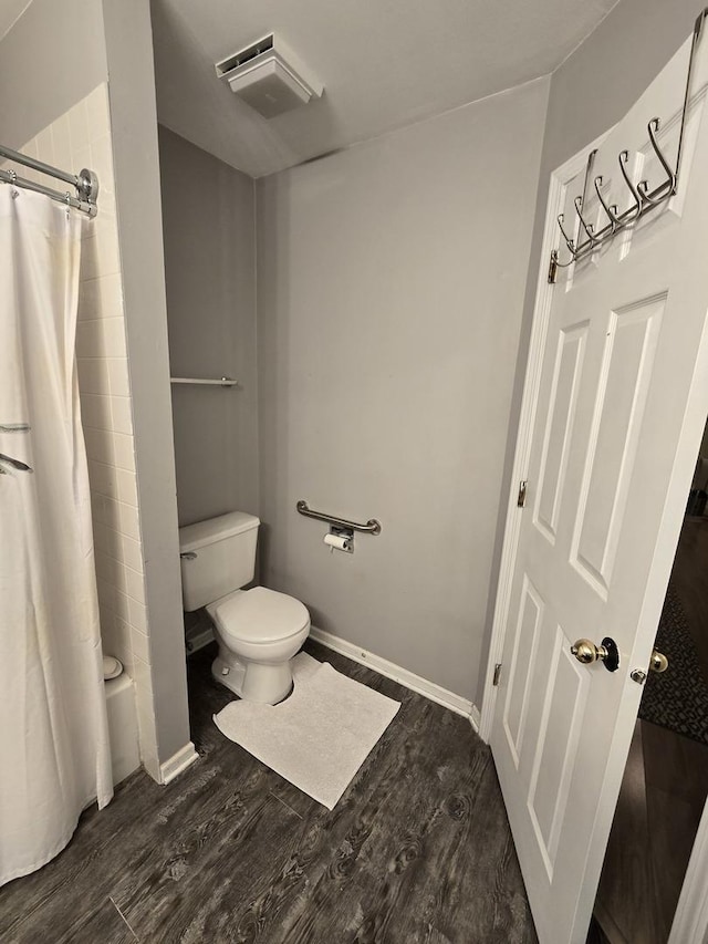 bathroom featuring hardwood / wood-style floors, toilet, and shower / tub combo