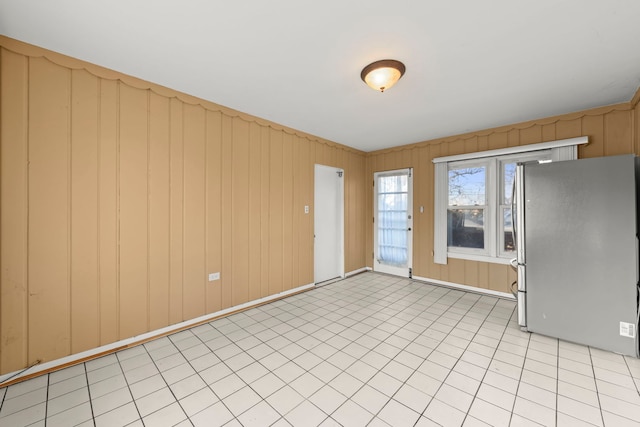 interior space with wooden walls and stainless steel refrigerator