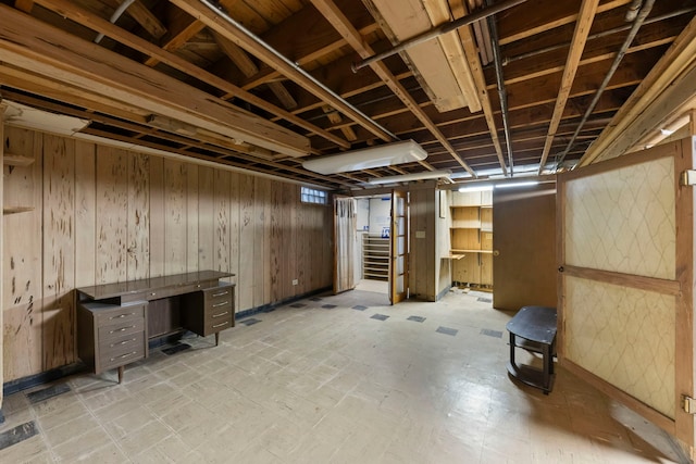 basement featuring wooden walls