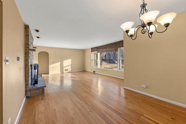 unfurnished living room with light hardwood / wood-style flooring and a chandelier