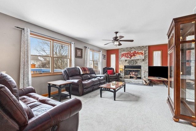 living room with carpet floors, a large fireplace, and ceiling fan