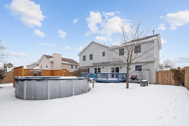 snow covered rear of property featuring a swimming pool side deck