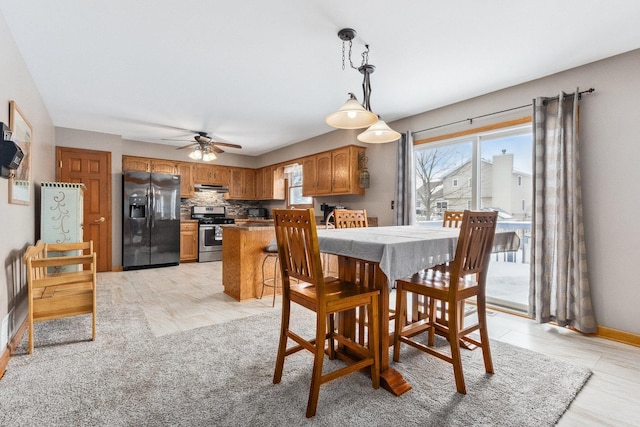 dining area with ceiling fan and light wood-type flooring