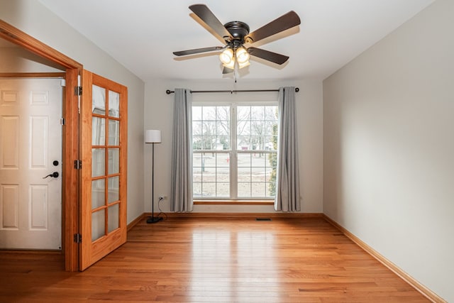 empty room with ceiling fan and light hardwood / wood-style floors