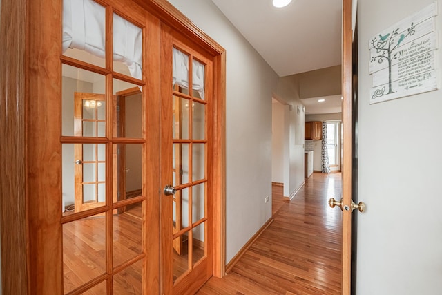 hall with light hardwood / wood-style flooring and french doors