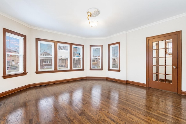 empty room featuring crown molding, dark hardwood / wood-style flooring, and plenty of natural light