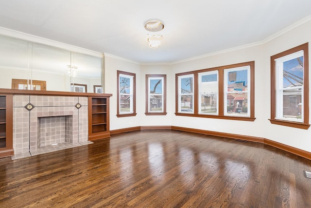 unfurnished living room featuring a tiled fireplace, crown molding, and hardwood / wood-style flooring