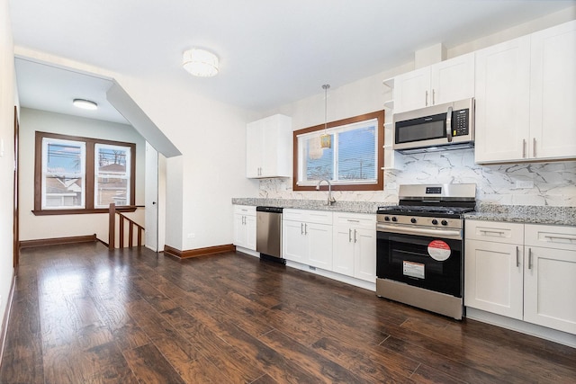 kitchen featuring decorative backsplash, appliances with stainless steel finishes, pendant lighting, and white cabinetry