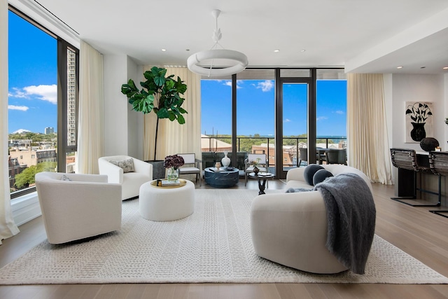 living room with wood-type flooring, expansive windows, and plenty of natural light