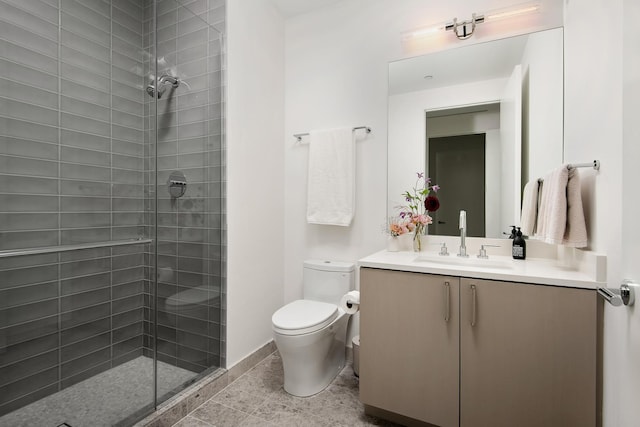 bathroom with tiled shower, vanity, and toilet