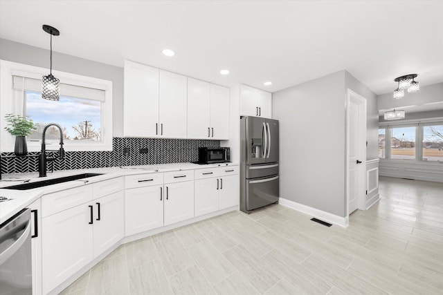 kitchen featuring white cabinetry, appliances with stainless steel finishes, sink, and backsplash