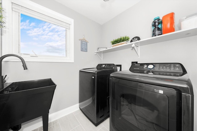 laundry room with washer and clothes dryer, sink, and light tile patterned floors