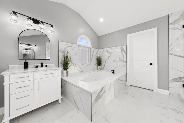 bathroom with lofted ceiling, tiled bath, and vanity