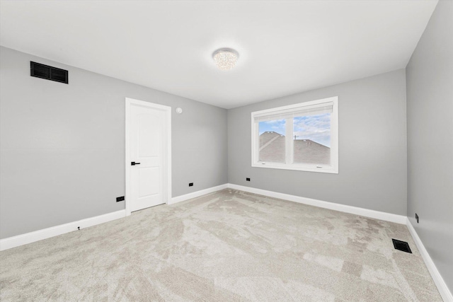 spare room featuring light colored carpet