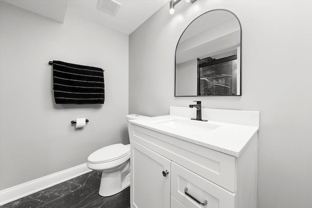 bathroom with vanity, a shower, and toilet