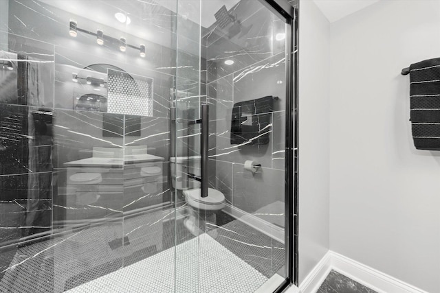 bathroom featuring a shower with door and toilet