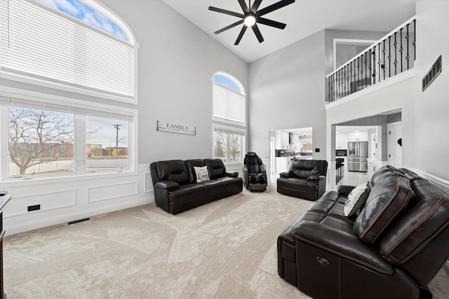 living room featuring ceiling fan, light colored carpet, and high vaulted ceiling