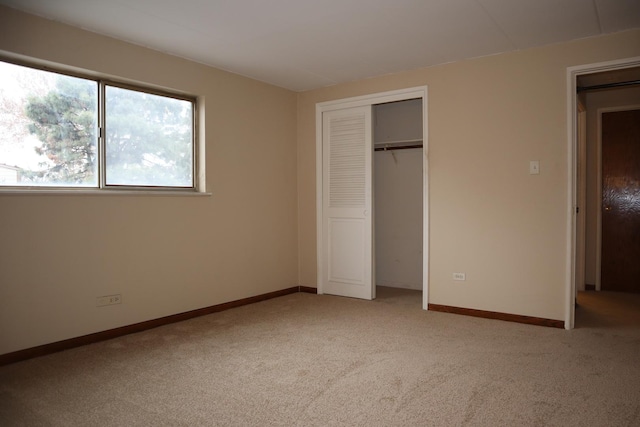 unfurnished bedroom featuring a closet and light colored carpet