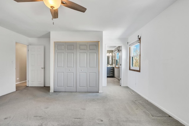 unfurnished bedroom with a closet, ceiling fan, and light carpet