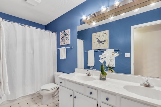 bathroom featuring toilet, vanity, and curtained shower