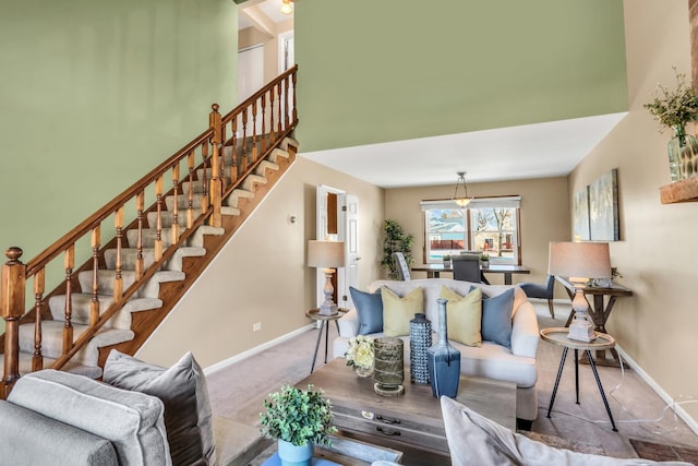 living room with a towering ceiling and carpet floors