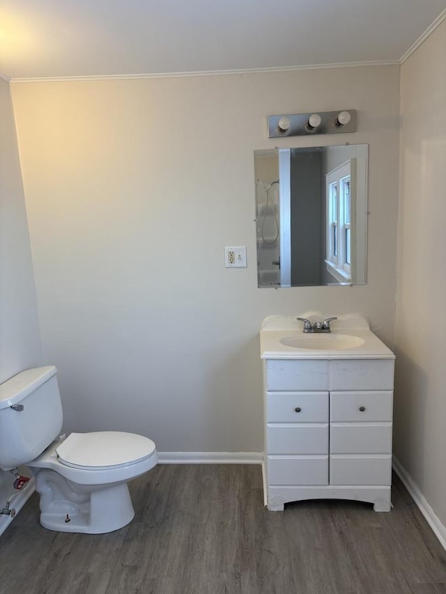 bathroom with vanity, ornamental molding, hardwood / wood-style floors, and toilet