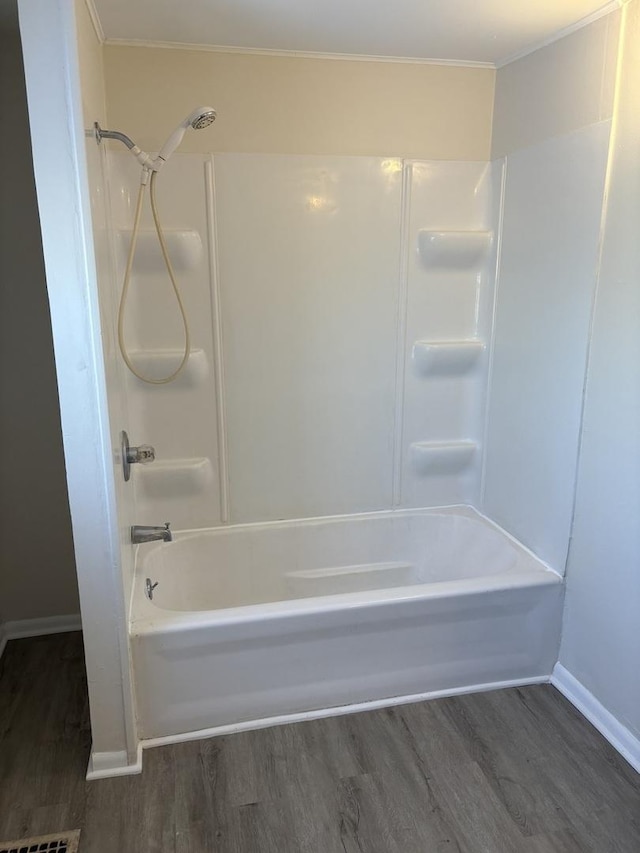 bathroom with ornamental molding, hardwood / wood-style floors, and  shower combination