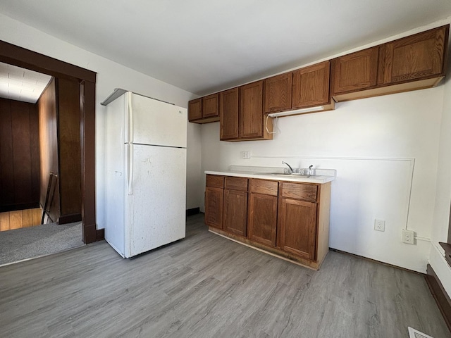 kitchen featuring white refrigerator, sink, and light hardwood / wood-style flooring