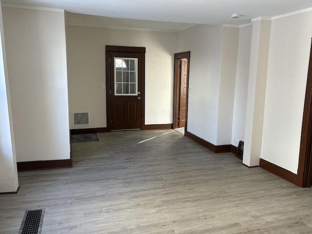 unfurnished room featuring ornamental molding and light hardwood / wood-style floors