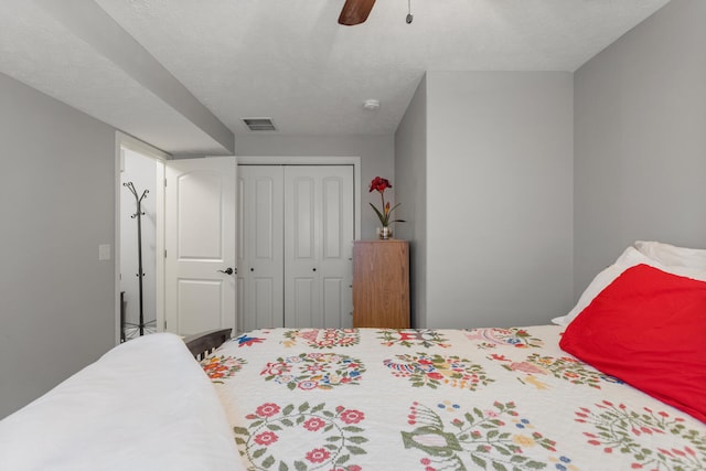 bedroom featuring a closet, ceiling fan, and a textured ceiling