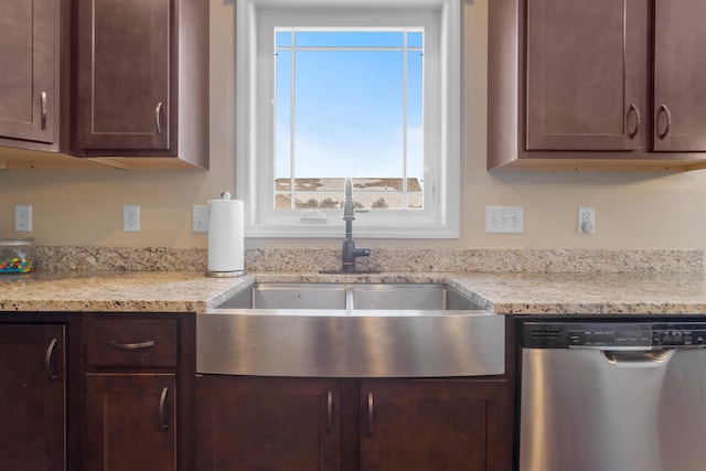 kitchen with sink, dishwasher, dark brown cabinets, and light stone countertops