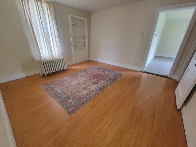 407 E Walnut St, Oglesby, IL 61348 - empty room with radiator, wood finished floors, and baseboards