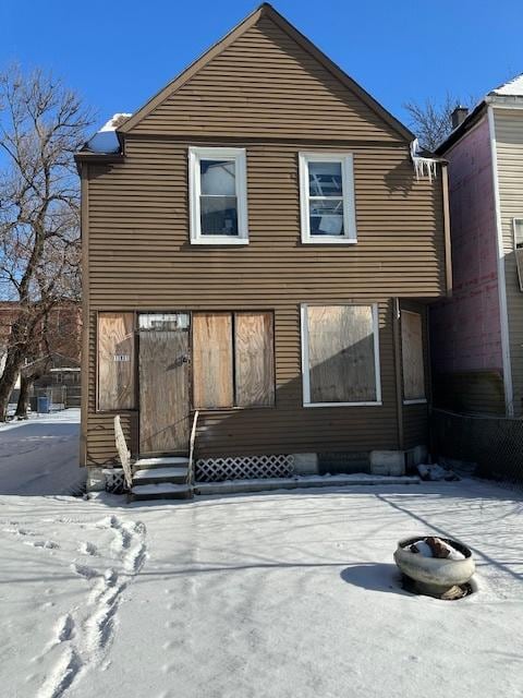 view of snow covered back of property